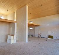 Das Innere der Hütte mit hoher Decke, roh bearbeiteten Wänden und feinen Holzdekorationen.