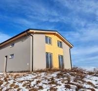 Eine Hütte in Dolná Lehota mit Holzeinrichtung, verschneitem Grundstück und bewölktem Himmel.
