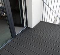 Balkon mit Holzboden in der Bodona-Straße, Teil eines Einzimmerapartments mit großem Fenster.