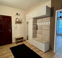 Flur mit Garderobenwand, Spiegel und Eingang zum Wohnzimmer, 3-Zimmer-Wohnung.