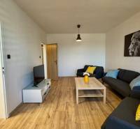 Wohnzimmer in einer 3-Zimmer-Wohnung mit Sofas und Holzboden.