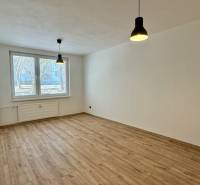 Ein geräumiges Zimmer in einer 3-Zimmer-Wohnung mit Holzboden und hängenden Lampen.