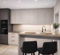 Küche in einer 2-Zimmer-Wohnung mit Holzboden, moderner Küchenzeile und Esstisch.