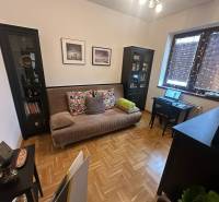 Wohnzimmer mit Sofa und Schreibtisch in einem Einfamilienhaus mit Holzboden.