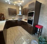 Küche in einem Einfamilienhaus mit Holzboden-Dekor und reichhaltiger Beleuchtung.