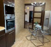 Eine Küche in einem Einfamilienhaus mit einem Holzboden und einem Glastisch.