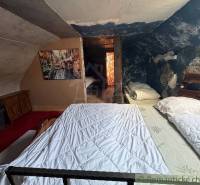 Dachbodenschlafzimmer in einem Einfamilienhaus mit einem Bild und einer blauen Wand voller Muster.