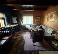 Wohnzimmer in einem Einfamilienhaus mit Holzboden und bequemen Sitzgelegenheiten.