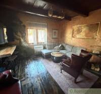 Wohnzimmer in einem Einfamilienhaus mit rustikalen Möbeln und einem Boden in Holzoptik.