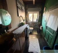 Ein Badezimmer in einem Einfamilienhaus mit dunklen Wänden, einer Toilette und einer Waschmaschine.