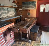 Rustikale Küche in einem Einfamilienhaus mit Backsteindetails und einem Boden in Holzoptik.