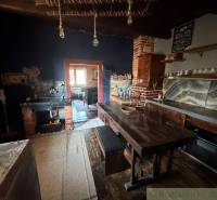 Eine Küche in einem Einfamilienhaus mit antikem Interieur, einem Holztisch und einem gemauerten Ofen.