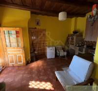 Ein Zimmer in einem Einfamilienhaus mit einem Ziegelboden, einer Holzdecke und gelben Wänden.