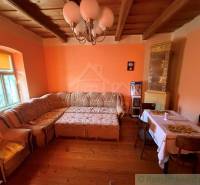 Wohnzimmer mit Ecksofa, Holzboden und Kachelkamin in einem Einfamilienhaus.