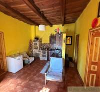 Innenraum eines Einfamilienhauses mit Holzbalkendecke und gelben Wänden.