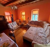 Wohnzimmer in einem Einfamilienhaus mit großem Sofa und Boden in Holzoptik.