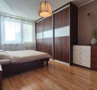 Schlafzimmer mit Bett und Einbauschrank, 2-Zimmer-Wohnung, Boden mit Holzdekor.