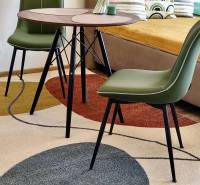 Innenraum einer Einzimmerwohnung mit einem bunten Teppich, einem Tisch und grünen Stühlen, Boden mit Dekor.