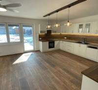 Küche in einem Einfamilienhaus mit Holzdekorboden und moderner Beleuchtung.