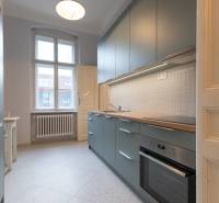 Küche mit weißen Fliesen in einer 3-Zimmer-Wohnung, ausgestattet mit einer modernen Küchenzeile und einem Herd.