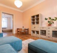 Wohnzimmer in einer 3-Zimmer-Wohnung mit Holzboden und pastellfarbenen Wänden.