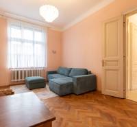 Helles Wohnzimmer mit Sofa, Kronleuchter und Holzboden in einer 3-Zimmer-Wohnung.