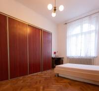 Schlafzimmer mit Bett, Boden mit Holzdekor, großer Schrank in einer 3-Zimmer-Wohnung.