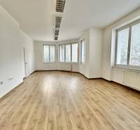 Büros mit großen Fenstern und einem Boden in Holzoptik.