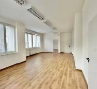 Büros mit Holzboden, weißen Wänden und Fenstern bieten einen hellen Arbeitsbereich.