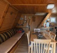 Innenraum einer Hütte mit Holzverkleidung, Treppen und Boden mit Holzdekor.