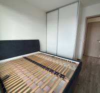 Schlafzimmer in einer 3-Zimmer-Wohnung mit Bettrahmen und Einbauschrank.
