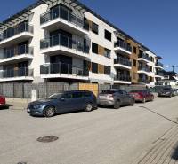 Neue Wohngebäude in der Topoľčianska-Straße in Košice, Stadtteil Západ, mit Autos, die vorne geparkt sind.