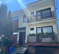 Einfamilienhaus in der Tálová-Straße in Veľké Orvište mit zwei Balkonen, Bäumen und einer Garage.