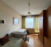 Ein Zimmer in einem Einfamilienhaus mit einem Holzboden, einem Sofa und einem großen Schrank.