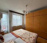 Schlafzimmer mit Doppelbett, Möbeln und Holzboden in einem Einfamilienhaus.
