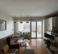 Wohnzimmer in einem Einfamilienhaus mit Kamin, Sofa und Boden in Holzoptik.