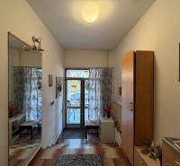 Eingangsbereich in einem Einfamilienhaus mit Fliesen, Spiegel und dekorativer Beleuchtung.