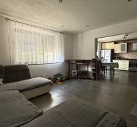 Wohnzimmer in einem Einfamilienhaus mit Blick auf die Küche, Boden mit Holzdekor.