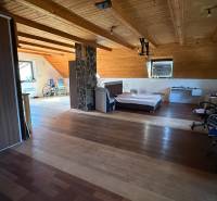 Dachzimmer mit Bett, Schrank und Holzboden in einem Einfamilienhaus.