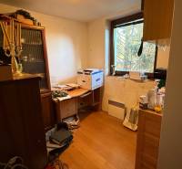 Ein Zimmer in einem Einfamilienhaus mit Einrichtung und einem Boden in Holzoptik.