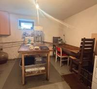 Eine Küche in einem Einfamilienhaus mit einfacher Möblierung und Geräten zur Lebensmittelverarbeitung.