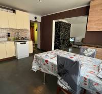 Küche in einem Einfamilienhaus mit Keramikfliesen, Esstisch und Geschirrspüler.