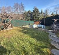 Der Garten des Einfamilienhauses in Lutila mit Bäumen und einem Gehweg in sonniger Umgebung.