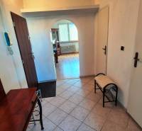 Flur mit einem Bogenübergang in einer 2-Zimmer-Wohnung, Boden mit Holzdekor, Spiegel, Bank.