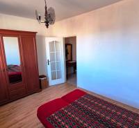 Schlafzimmer in einer 2-Zimmer-Wohnung mit Holzboden, Kleiderschrank und Bett.