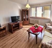 Wohnzimmer in einer Zweizimmerwohnung mit Holzdekorboden und klassischer Einrichtung.