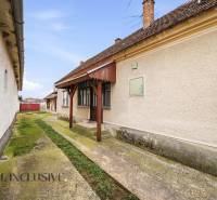 Ein Einfamilienhaus in Topoľníky mit gepflegter Fassade, Veranda und Betonweg.