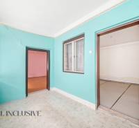 Ein Zimmer in einem Einfamilienhaus mit bunten Wänden, Laminatboden und einem großen Fenster.