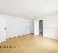 Ein geräumiges Zimmer in einem Einfamilienhaus mit einem Holzboden und einfacher Beleuchtung.