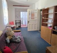 Wohnzimmer eines Einfamilienhauses mit Sofa, Regal und Spielzeug auf dem Boden.